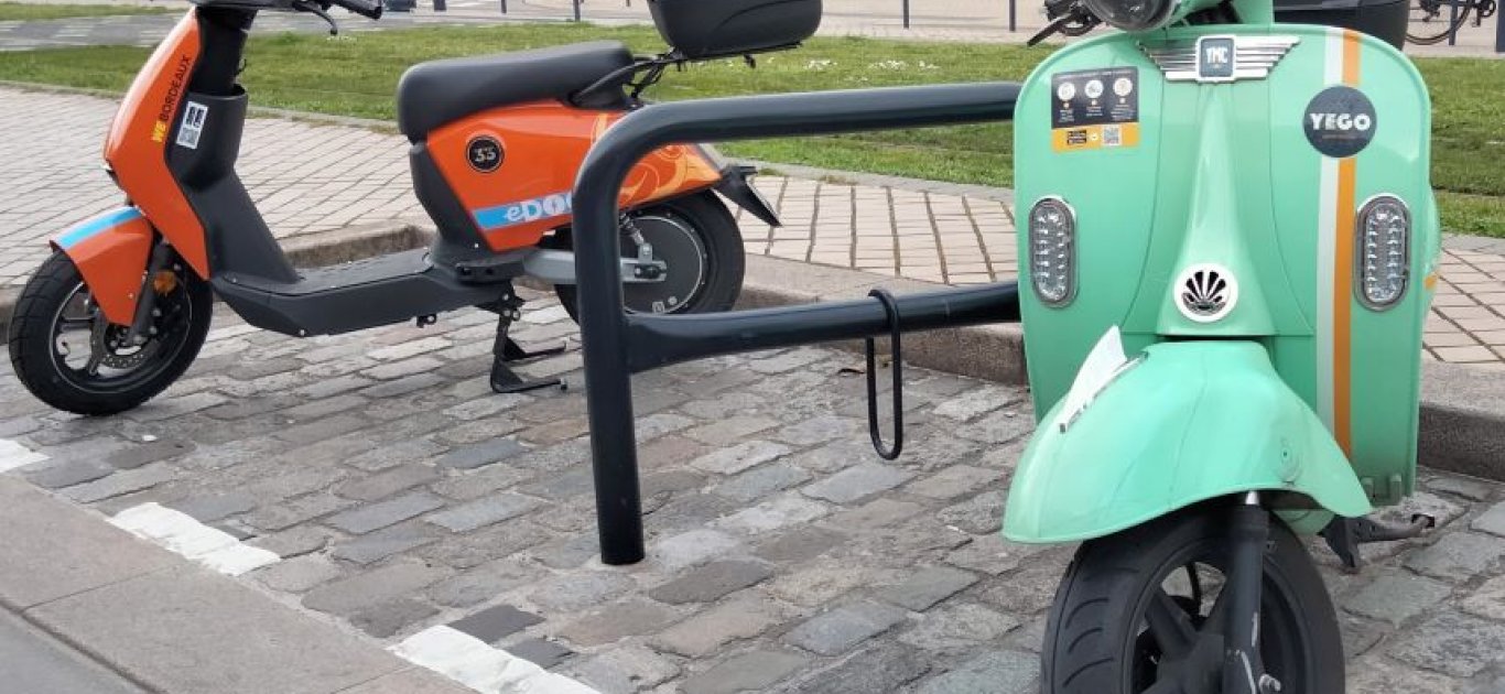 2 Scooters en libre service Yego et Edog garés sur un stationnement prévu à cet effet