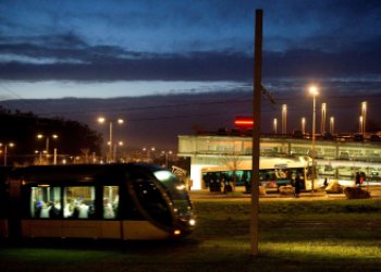 Vue de nuit du Parc Relais Buttinière, avec un tram arrivant sur la gauche de l'image