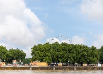 Vue depuis la Garonne sur les quais et au fond la grande roue de la place des Quinconces