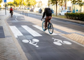 Vue sur la piste cyclable bidirectionnelle du quais des Chartrons à Bordeaux, avec 2 cyclistes la parcourant