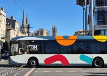 Vue d'un bus électrique passant devant la cathédrale et le palais de justice