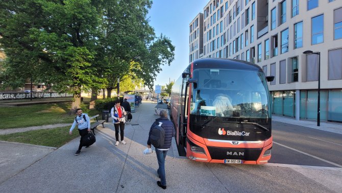 Vue de la halte routière Belcier avec un bus Blabla Car sur la droite et des passagers qui attendent à l'arrêt à gauche