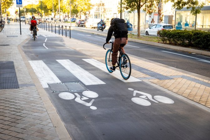 Vue sur la piste cyclable bidirectionnelle du quais des Chartrons à Bordeaux, avec 2 cyclistes la parcourant